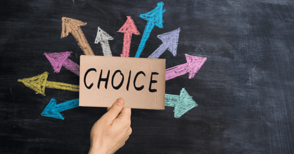 hand holding a carboard sign that says "Choice" in front a chalk board with arrows coming out