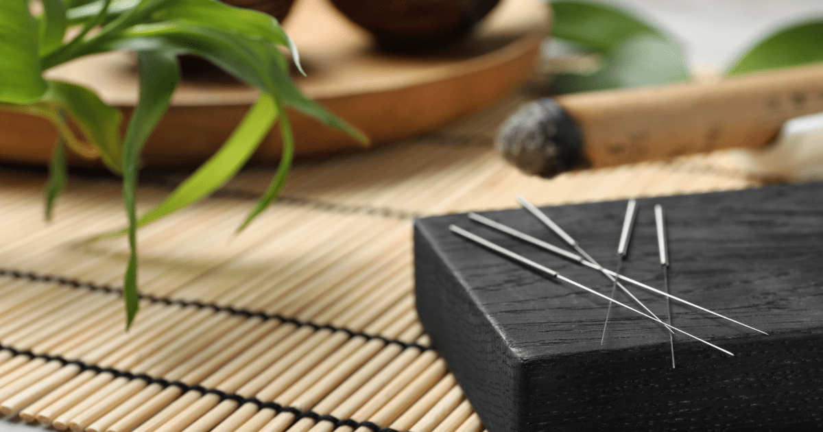 A picture of acupuncture needles over bamboo.